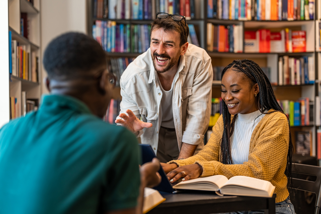 Mentor and students studying together in a library