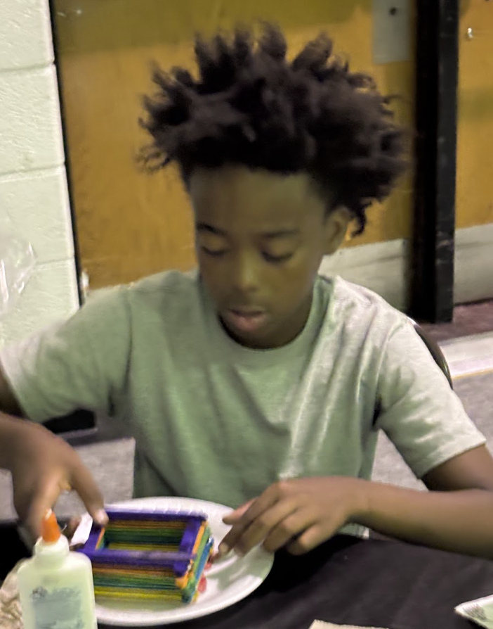Camper doing a popsicle-stick craft